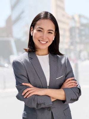 Smiling woman in professional attire outdoors.