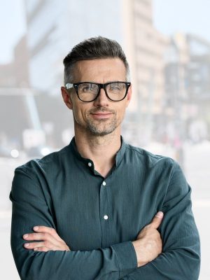 Confident man with glasses standing outdoors